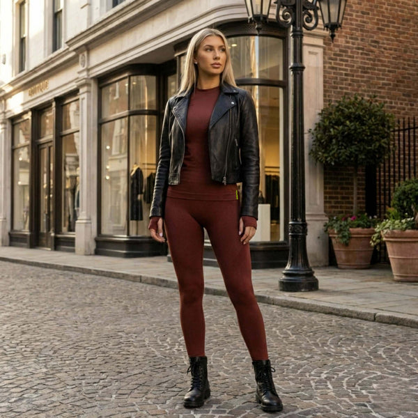 Modella in posa rilassata con leggings mogano Gsclosure per mostrare la vestibilità e il sostegno muscolare freestyle.